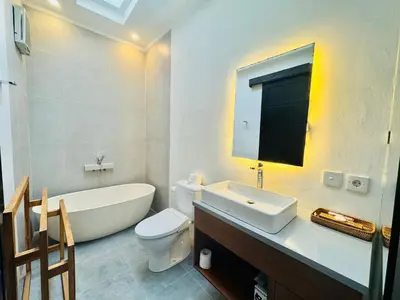 a bathroom with a tub and a toilet and a sink at Villa Banua Seminyak in Seminyak