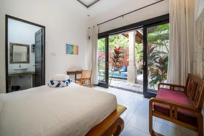 a bedroom with a bed and a view of a bathroom at Villa Banua Seminyak in Seminyak