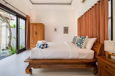 a bedroom with a bed and a large window at Villa Banua Seminyak in Seminyak