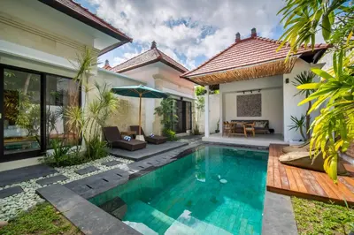 a villa with a swimming pool in front of a house at Villa Banua Seminyak in Seminyak