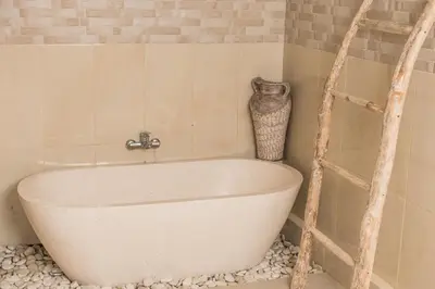 a white bath tub in a bathroom with a shelf at Relax Bali Villas in Legian