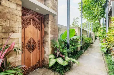 an entrance to a building with a wooden door at Kundalini Residence in Seminyak