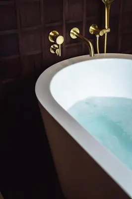 a bath tub filled with blue water in a bathroom at Munno Villa in Canggu