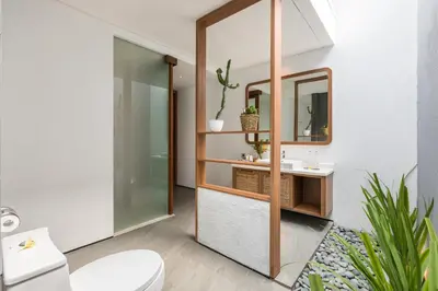 a bathroom with a toilet and a sink and a mirror at Fenosa Seminyak Villas in Seminyak