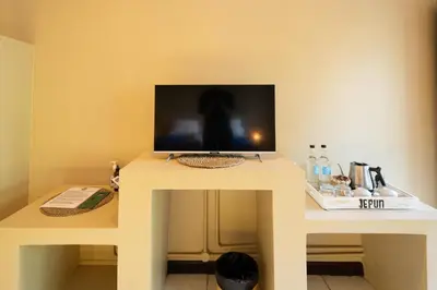 a white table with a tv on top of it at Jepun BnB Bali in Seminyak