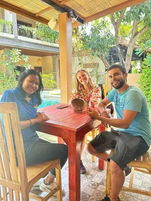 a group of people sitting at a wooden table at Jepun BnB Bali in Seminyak