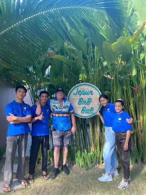 a group of men in blue shirts holding a sign at Jepun BnB Bali in Seminyak