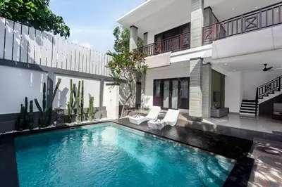 a swimming pool in front of a house at Maja Villa Batubelig by GenuineHost in Canggu
