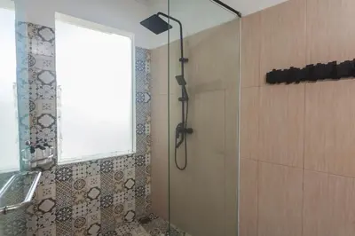 a bathroom with a shower with a window and a window at Maja Villa Batubelig by GenuineHost in Canggu