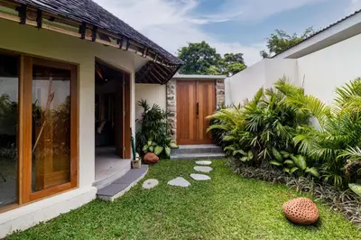 a garden outside a house with a lawn at Umani Village in Kerobokan