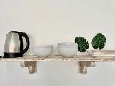 a shelf with three bowls and plates and a kettle at VILLA LUNA in Kerobokan
