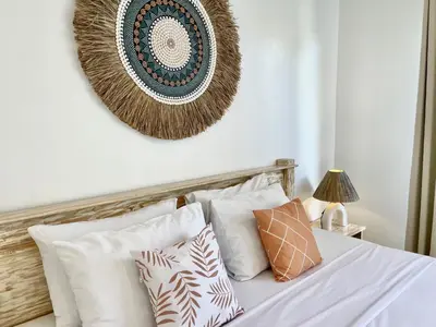 a bedroom with a bed with white sheets and pillows at VILLA LUNA in Kerobokan