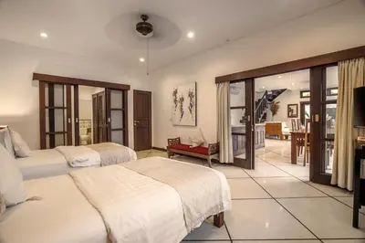 a bedroom with two beds and a living room at Villa Gading by Alfred in Bali in Seminyak
