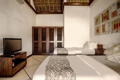 a bedroom with a bed and a flat screen tv at Villa Gading by Alfred in Bali in Seminyak