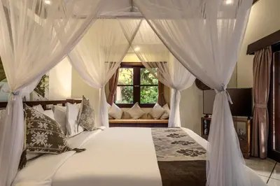 a bedroom with a canopy bed with white curtains at Villa Gading by Alfred in Bali in Seminyak