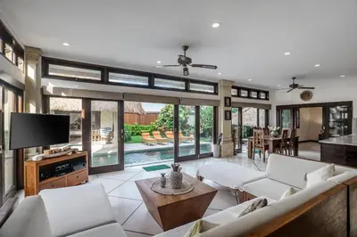 a living room with white furniture and a tv at Villa Gading by Alfred in Bali in Seminyak