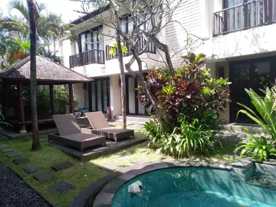 a backyard with a swimming pool and a house at LBV Seminyak Apartment in Seminyak
