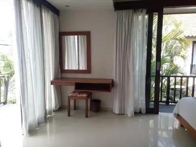 a bedroom with a desk and a bed and a mirror at LBV Seminyak Apartment in Seminyak