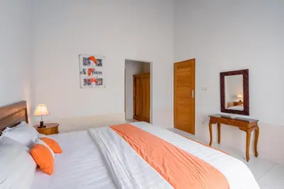a bedroom with a large bed and a mirror at Villa Padma by Best Deals Asia Hospitality in Nusa Dua