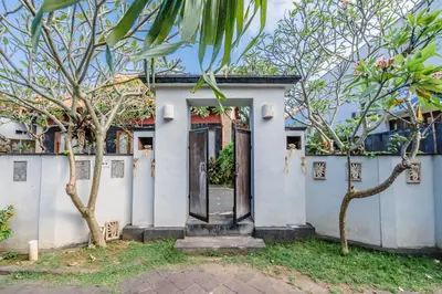 a white house with trees in front of it at Villa Padma by Best Deals Asia Hospitality in Nusa Dua