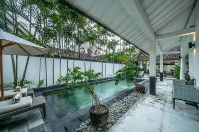 a swimming pool in a building with a patio at Villa Zebra Walking Distance to Potato Head in Seminyak
