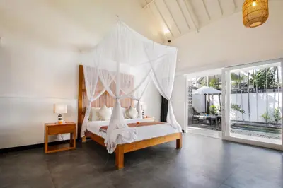 a bedroom with a bed with a canopy at Villa Zebra Walking Distance to Potato Head in Seminyak