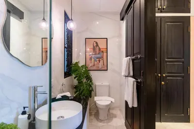 a bathroom with a sink and a toilet and a mirror at Villa Caorrun Canggu in Canggu