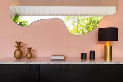 a room with a table with a lamp and a mirror at Villa Caorrun Canggu in Canggu