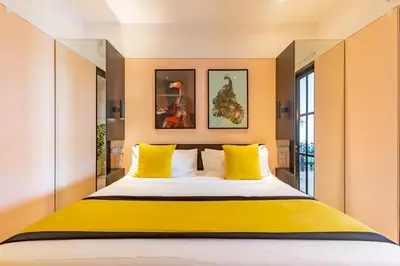 a bedroom with a large bed with yellow pillows at Villa Caorrun Canggu in Canggu