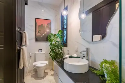 a bathroom with a sink and a toilet and a mirror at Villa Caorrun Canggu in Canggu