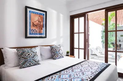a bedroom with a bed with a picture on the wall at Villa Anahera Seminyak in Seminyak