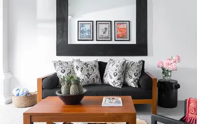 a living room with a black couch with pillows at Villa Anahera Seminyak in Seminyak