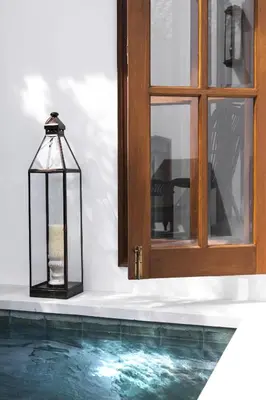 a candle in a cage next to a swimming pool at Villa Anahera Seminyak in Seminyak