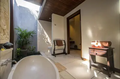 a bathroom with a tub and a chair and a table at Villa MD 3 bedroom, Sunny Pool in Eat st location in Seminyak