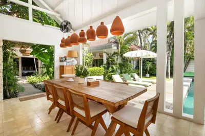 a dining room with a wooden table and chairs at Villa Gauguin by Villa Finder in Seminyak