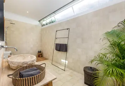a bathroom with a tub and a glass shower at Villa Gauguin by Villa Finder in Seminyak