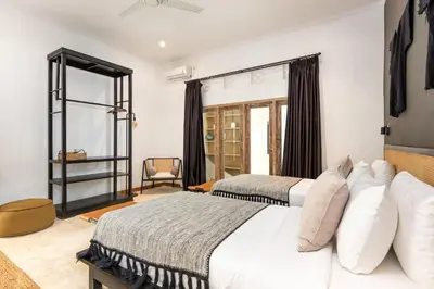 a bedroom with two beds and a window at Villa Gauguin by Villa Finder in Seminyak