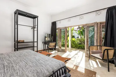 a bedroom with a bed and a large window at Villa Gauguin by Villa Finder in Seminyak