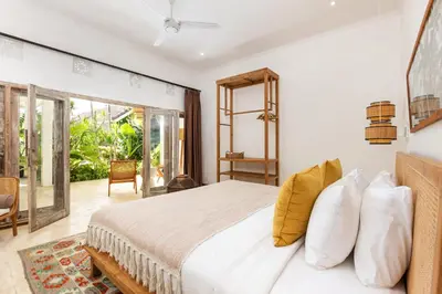 a bedroom with a bed and a large window at Villa Gauguin by Villa Finder in Seminyak