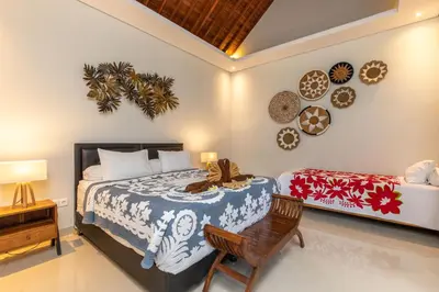 a bedroom with a bed and a desk and a chair at Villa Kamboja Premium walk to double six Beach - enclosed living room with AC in Seminyak
