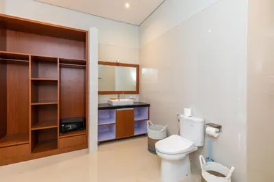 a bathroom with a toilet and a sink at Villa Kamboja Premium walk to double six Beach - enclosed living room with AC in Seminyak