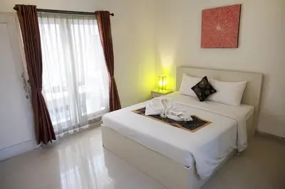 a bedroom with a white bed with a tray with flowers on it at Gaing Mas Residence By Gaing Mas Group in Jimbaran