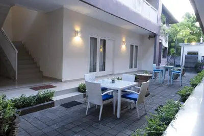 a patio with a white table and chairs and stairs at Gaing Mas Residence By Gaing Mas Group in Jimbaran