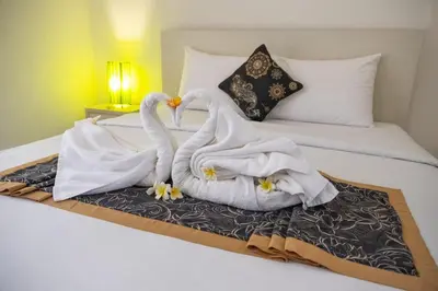 two swans sitting on a bed with towels at Gaing Mas Residence By Gaing Mas Group in Jimbaran