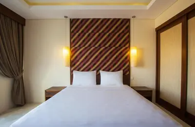 a bedroom with a large white bed with two pillows at M Suite Bali in Seminyak