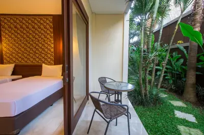 a balcony with a bed and a table and chairs at M Suite Bali in Seminyak
