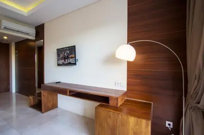 a room with a wooden wall with a desk at M Suite Bali in Seminyak