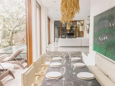 a dining room with a table with plates on it at AB Villa & Apartments in Seminyak