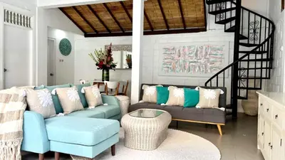 a living room with two blue couches and a table at Tiga Pantai Villa Legian in Legian