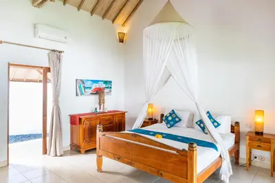 a bedroom with a bed with a mosquito net at Villa Damai Kecil Seminyak by Adam Jyota Management in Seminyak